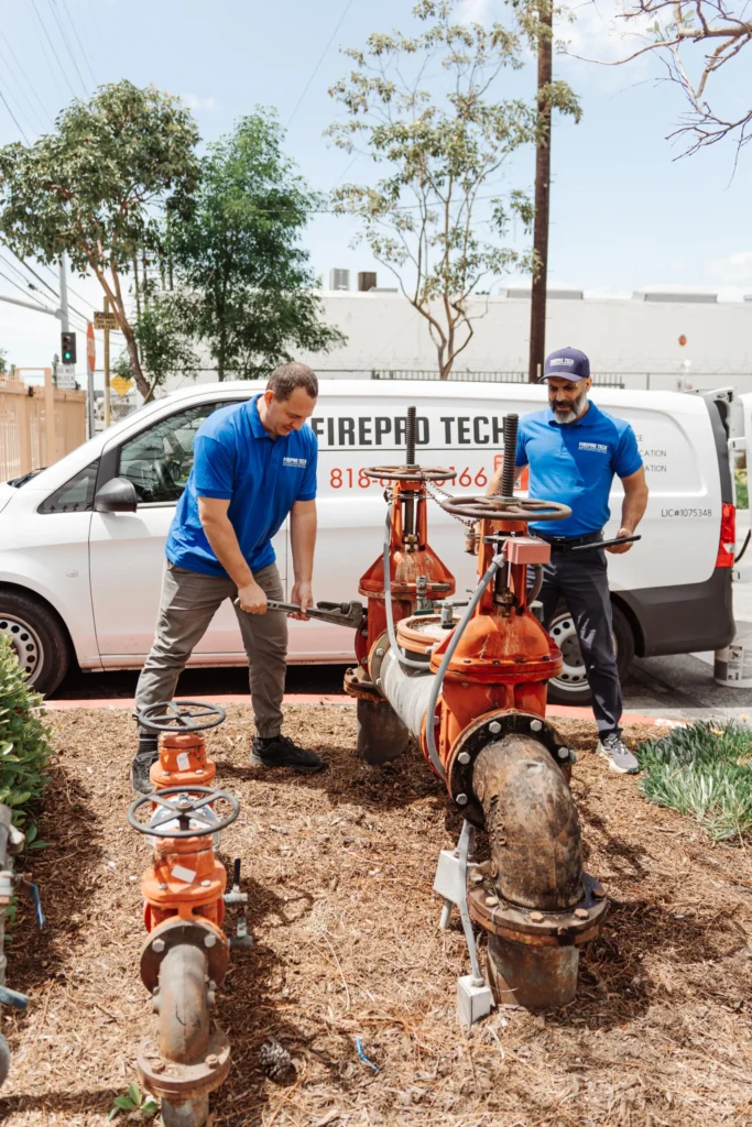technicians work on the draining sprinkler system